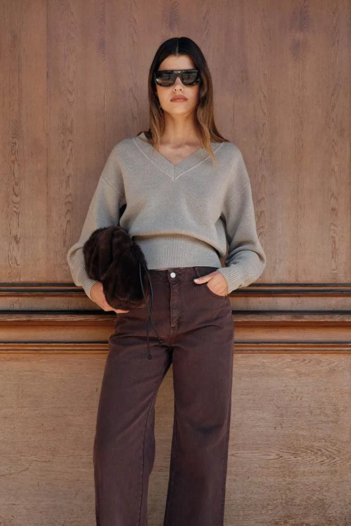 Woman wearing brown jeans with a beige knit sweater and brown boots for a cozy neutral outfit