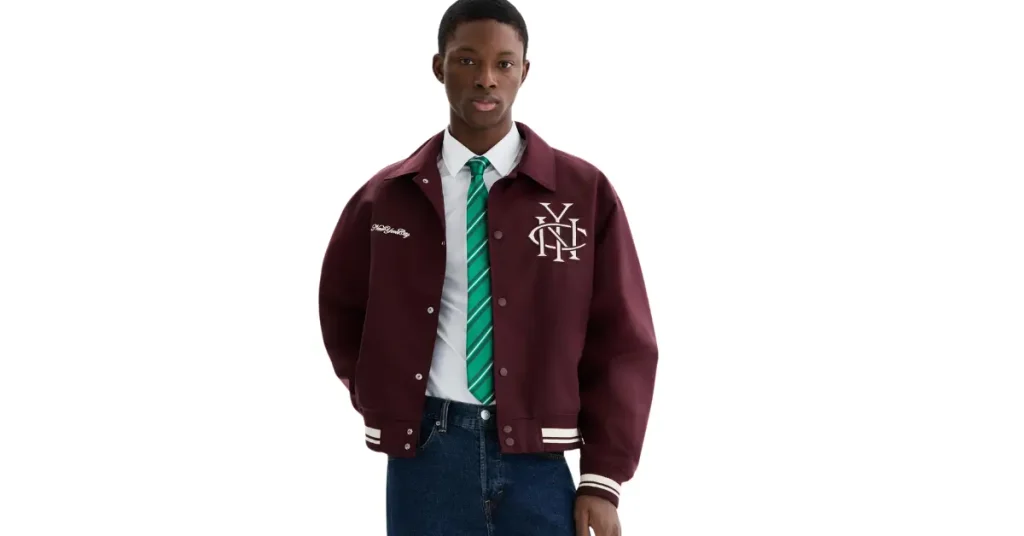 Burgundy varsity jacket styled with a white shirt and jeans for fall fashion