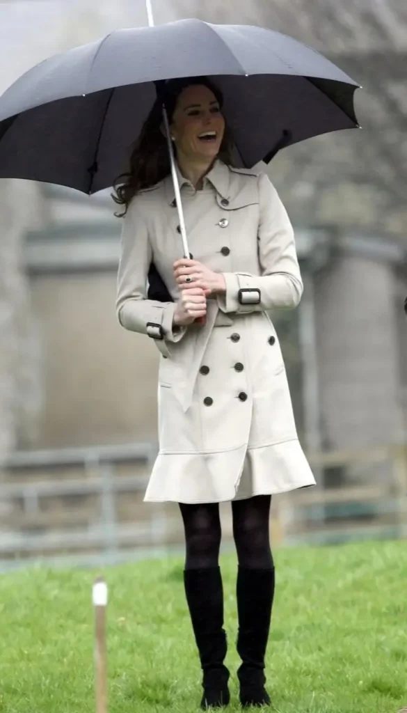 Kate Middleton wearing a cream trench coat with black tights and boots for a fall outfit