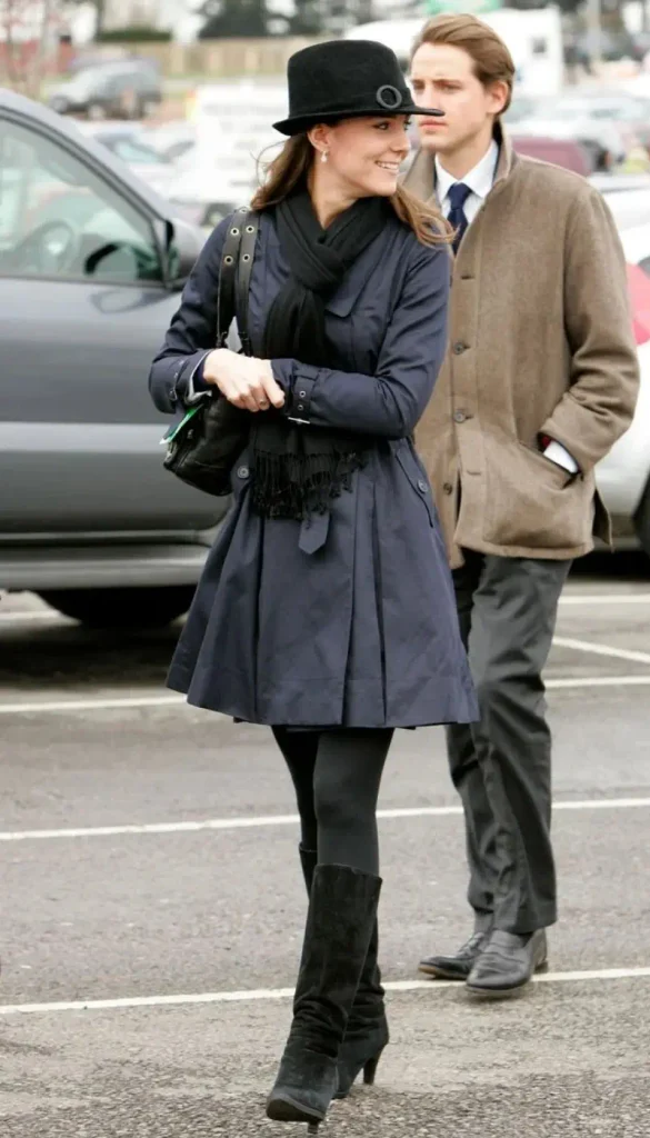 Kate Middleton wearing a navy trench coat with black boots for a classic fall look