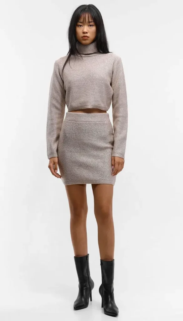 Beige knit skirt set styled with ankle boots for a classic fall outfit.