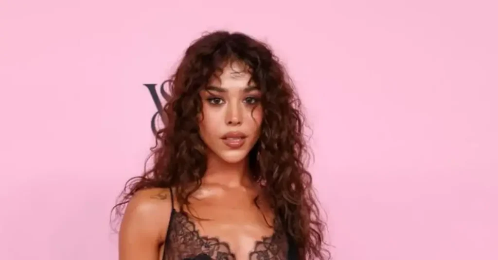 Singer wearing a black lace gown at the Victoria’s Secret Fashion Show pink carpet